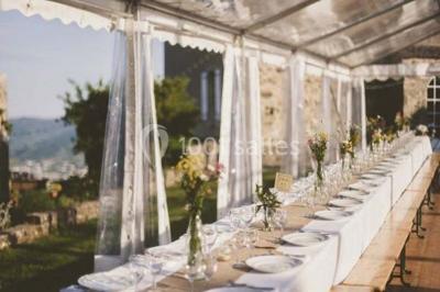 Chambre lumineuse avec lit double, canapé, meubles en bois, plafond avec poutres bleues et fenêtre donnant sur l'extérieur.