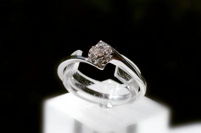 Main portant deux bagues argentées ornées de petits strass, posée sur une surface claire.