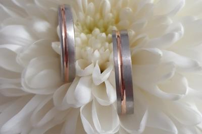 Main portant deux bagues argentées ornées de petits strass, posée sur une surface claire.