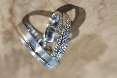 Main portant deux bagues argentées ornées de petits strass, posée sur une surface claire.