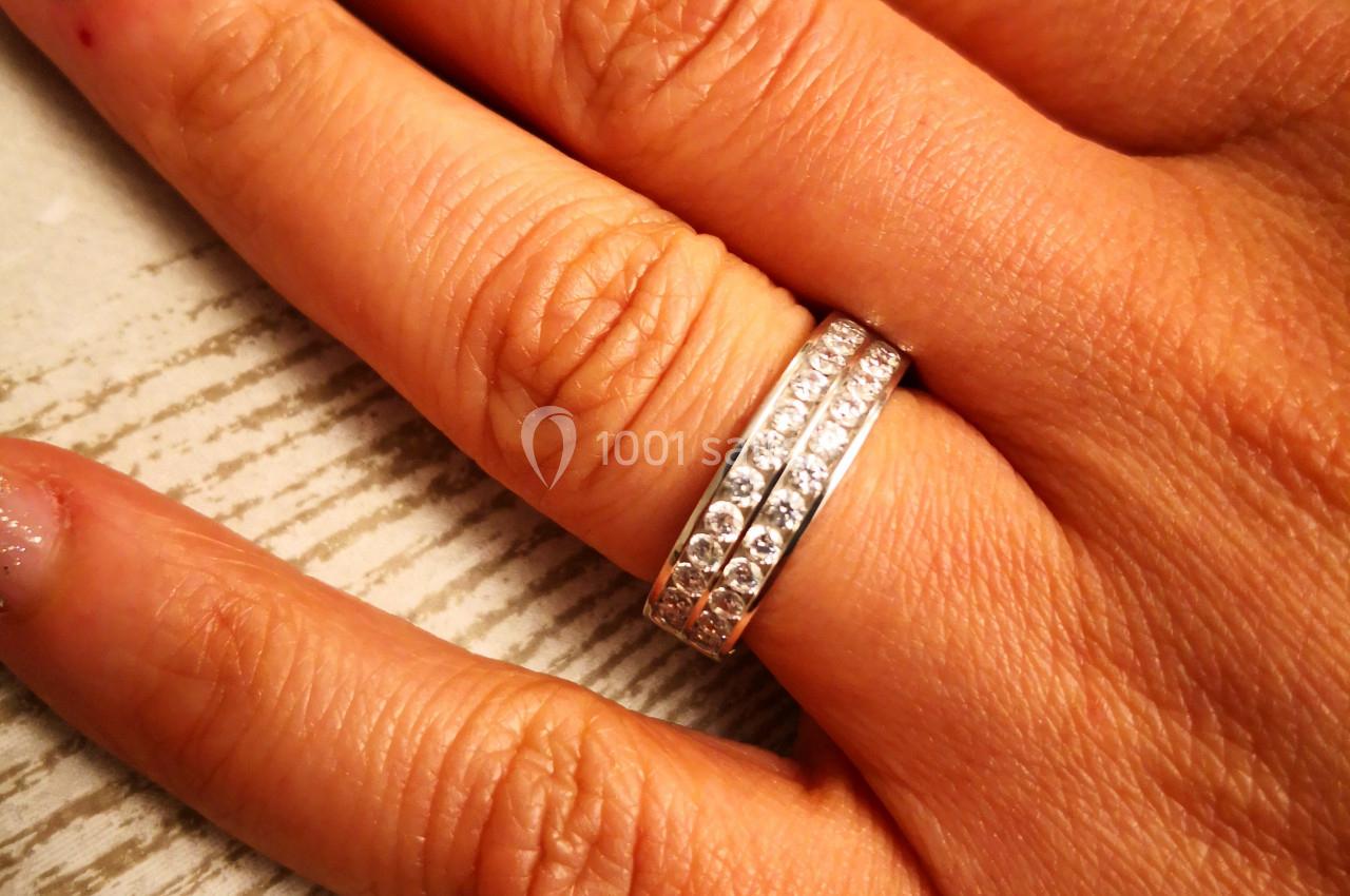 Main portant deux bagues argentées ornées de petits strass, posée sur une surface claire.