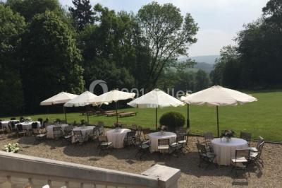 Salle décorée avec des plantes suspendues, des lampes en osier, une table haute et des chaises en métal.