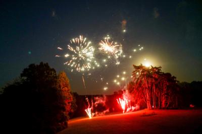 Salle décorée avec des plantes suspendues, des lampes en osier, une table haute et des chaises en métal.