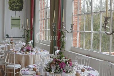 Salle de bain avec cabine de douche arrondie en verre, lavabo encastré et murs carrelés beige.