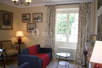 Salle de bain avec cabine de douche arrondie en verre, lavabo encastré et murs carrelés beige.