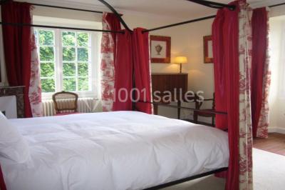 Miniature La chambre rouge Salon lumineux avec fauteuils bleus, table basse, cheminée, lampes, cadres au mur et grande fenêtre avec rideaux fleuris.