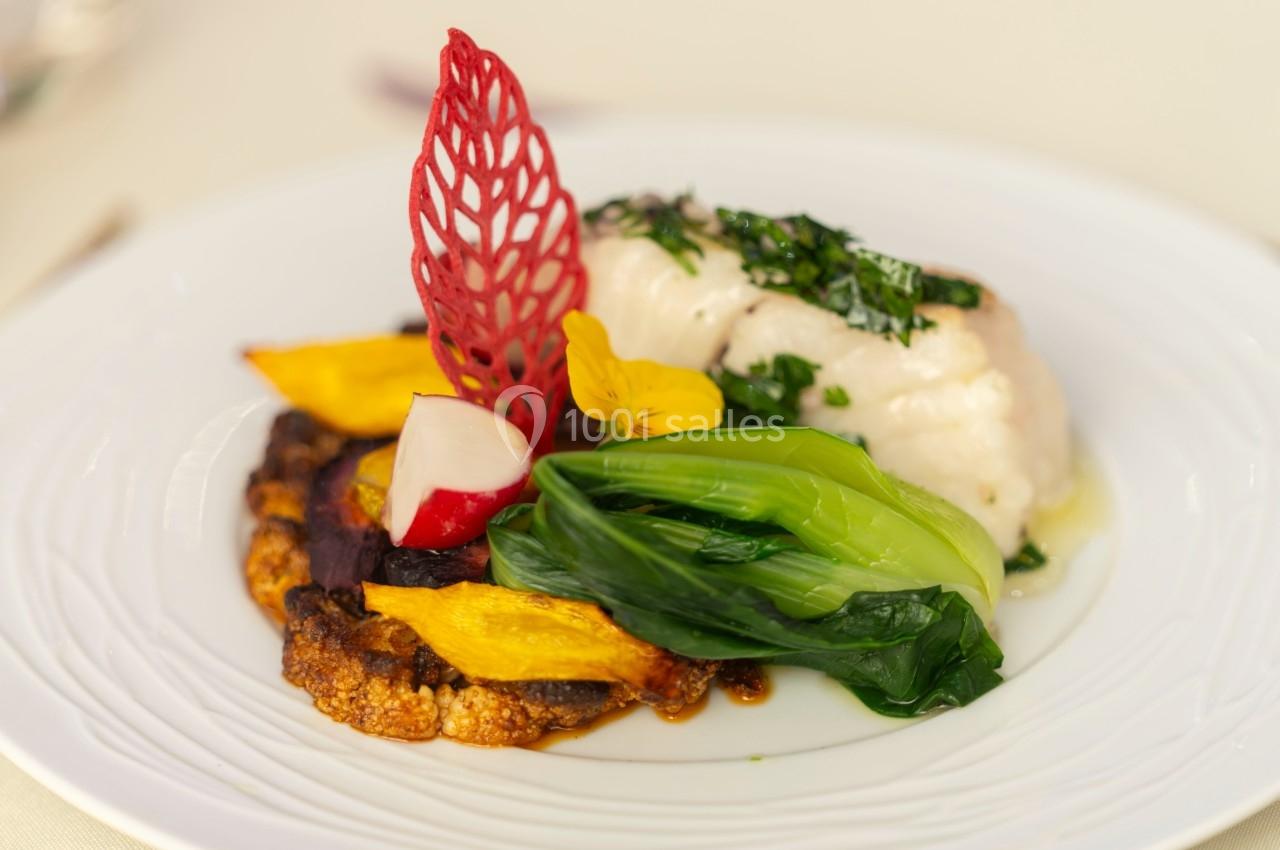 Assiette gastronomique avec poisson blanc, légumes colorés, purée et décoration rouge en dentelle comestible.