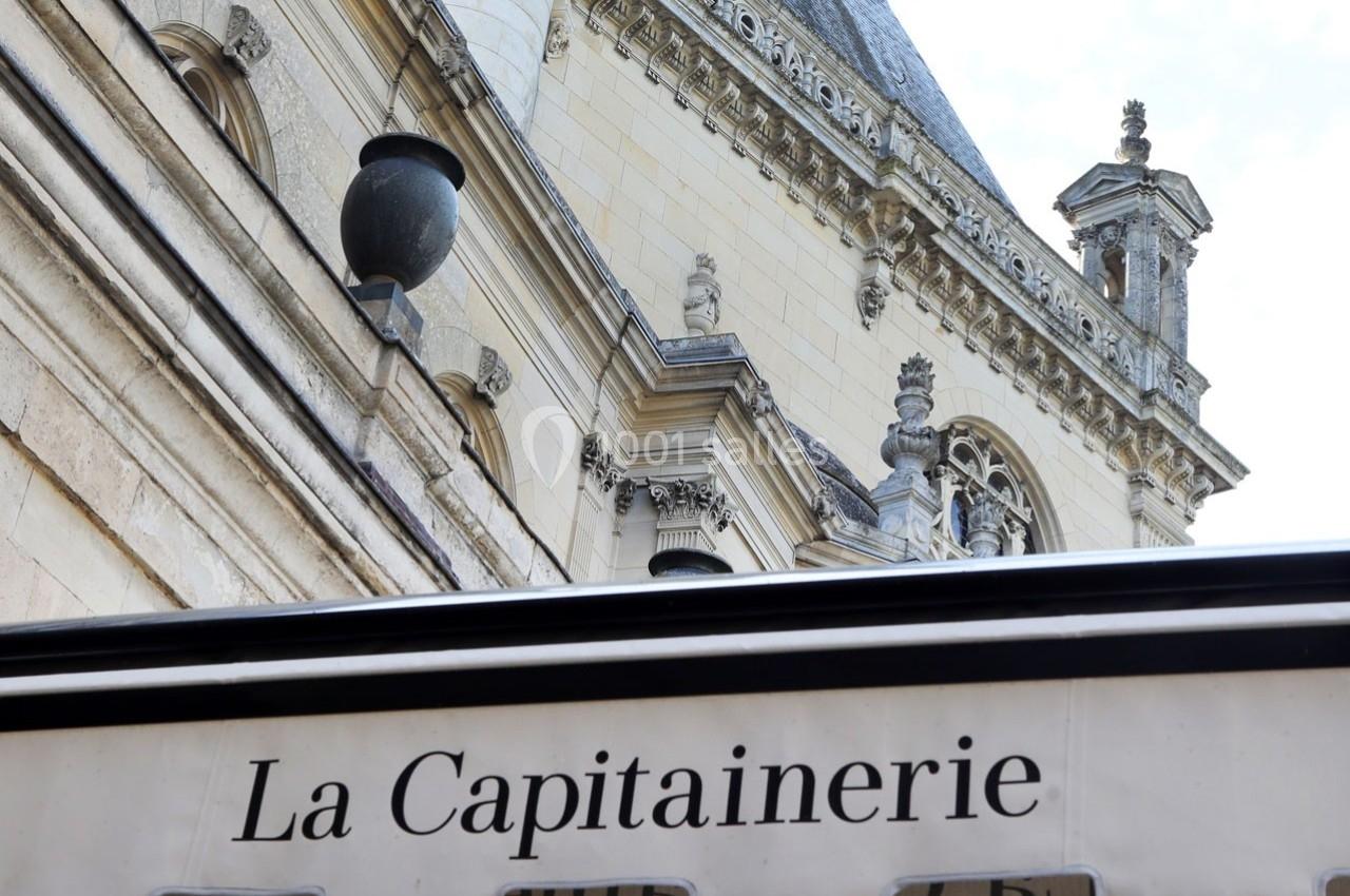 Façade en pierre d'un bâtiment historique avec une enseigne ’La Capitainerie’ visible au premier plan.