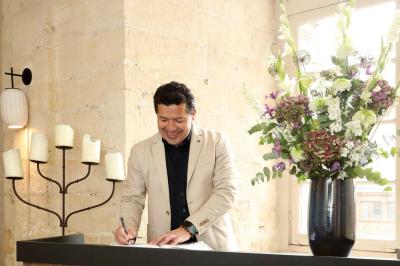 Façade en pierre d'un bâtiment historique avec une enseigne ’La Capitainerie’ au premier plan.