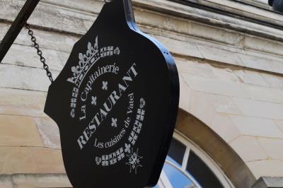 Façade en pierre d'un bâtiment historique avec une enseigne ’La Capitainerie’ au premier plan.