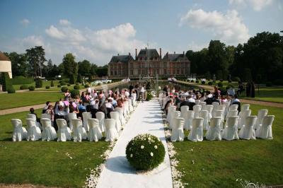 Salle de bain avec cabine de douche arrondie en verre, lavabo intégré dans un meuble en bois et carrelage beige.