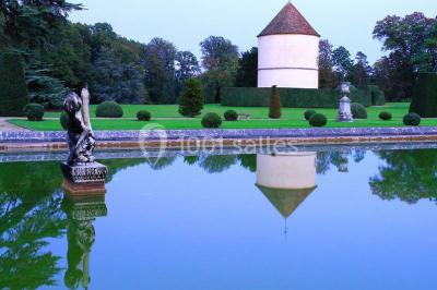 Salle de bain avec cabine de douche arrondie en verre, lavabo intégré dans un meuble en bois et carrelage beige.