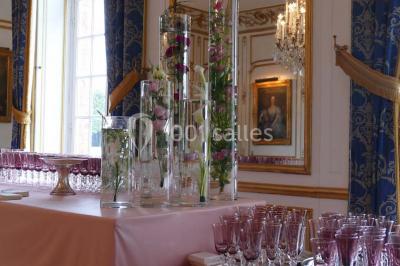 Salle de bain avec cabine de douche arrondie en verre, lavabo intégré dans un meuble en bois et carrelage beige.