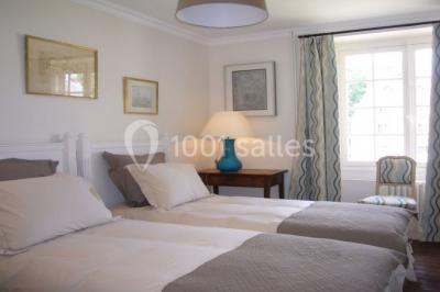 Salle de bain avec cabine de douche arrondie en verre, lavabo intégré dans un meuble en bois et carrelage beige.