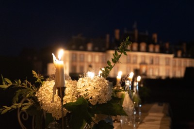 Cuisine équipée avec micro-ondes, évier, cafetière et table dressée pour quatre personnes près d'une fenêtre lumineuse.