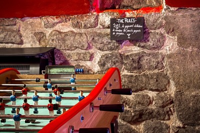 Comptoir lumineux dans une pièce voûtée en pierre, décoré de plantes, lampes et guirlandes lumineuses.