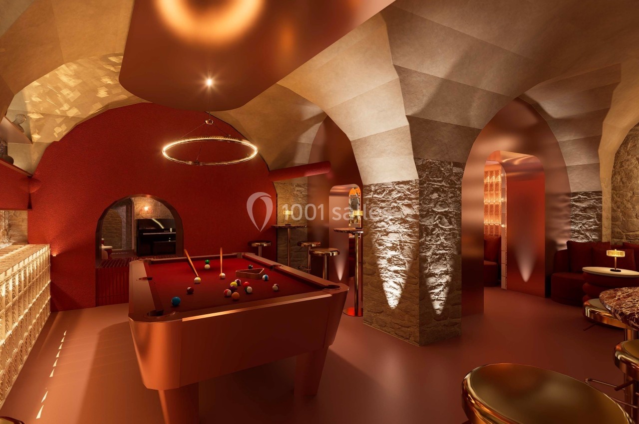 Salle voûtée au décor chaleureux avec billard rouge au centre, éclairage tamisé et mobilier élégant.