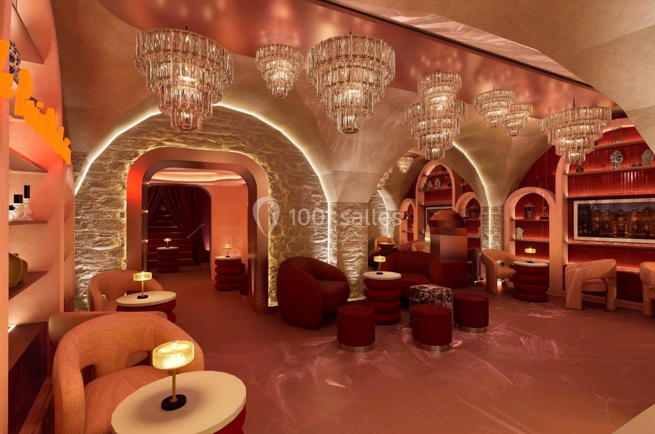 Salle élégante avec arches en pierre, lustres en cristal, fauteuils confortables et éclairage tamisé.