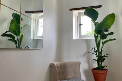 Champ de coquelicots rouges au premier plan avec un bâtiment en pierre et des toits en arrière-plan sous un ciel nuageux.