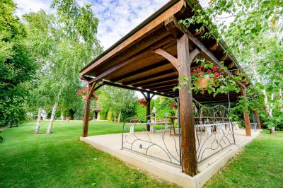 Champ de coquelicots rouges au premier plan avec un bâtiment en pierre et des toits en arrière-plan sous un ciel nuageux.