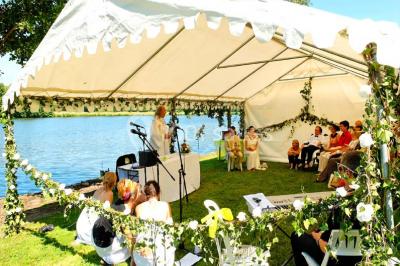 Piscine intérieure avec eau bleue, entourée de plantes en pot et éclairée par des appliques murales.