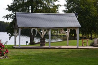 Piscine intérieure avec eau bleue, entourée de plantes en pot et éclairée par des appliques murales.