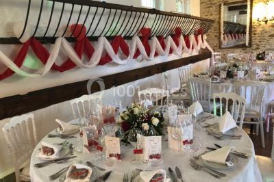 Miniature Rouge et blanc dans Les Ecuries Salle de réception décorée pour un événement, avec tables dressées, nappes blanches, fleurs et lumière naturelle.