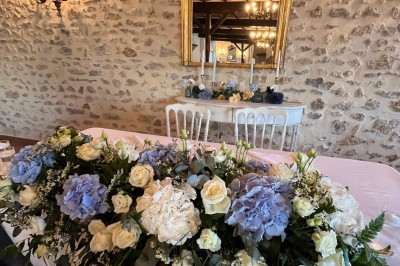 Miniature Table d'honneur des Bergeries Salle de réception décorée pour un événement, avec tables dressées, nappes blanches, fleurs et lumière naturelle.