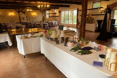 Miniature Un gouter bien au chaud dans les Bergeries Salle de réception décorée pour un événement, avec tables dressées, nappes blanches, fleurs et lumière naturelle.