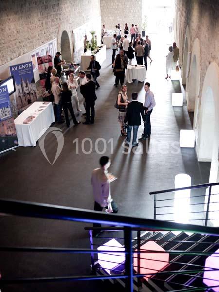 Des personnes discutent et circulent dans un espace intérieur lumineux, aménagé pour un événement professionnel.