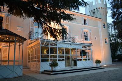 Salle de réunion avec parquet, chaises alignées, table avec projecteur et grandes fenêtres donnant sur l'extérieur.