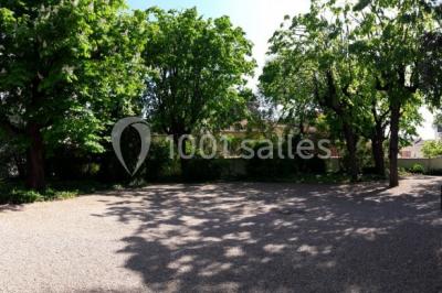 Salle de réunion avec parquet, chaises alignées, table avec projecteur et grandes fenêtres donnant sur l'extérieur.