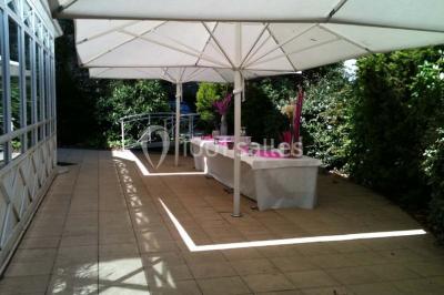Salle de réunion avec parquet, chaises alignées, table avec projecteur et grandes fenêtres donnant sur l'extérieur.