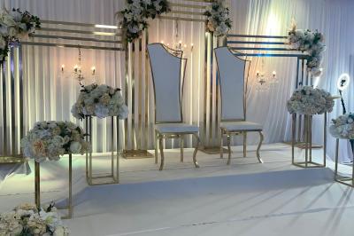 Verres de cocktails colorés garnis de fruits et de feuilles, disposés sur une table lors d'un événement en extérieur.