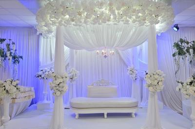 Verres de cocktails colorés garnis de fruits et de feuilles, disposés sur une table lors d'un événement en extérieur.