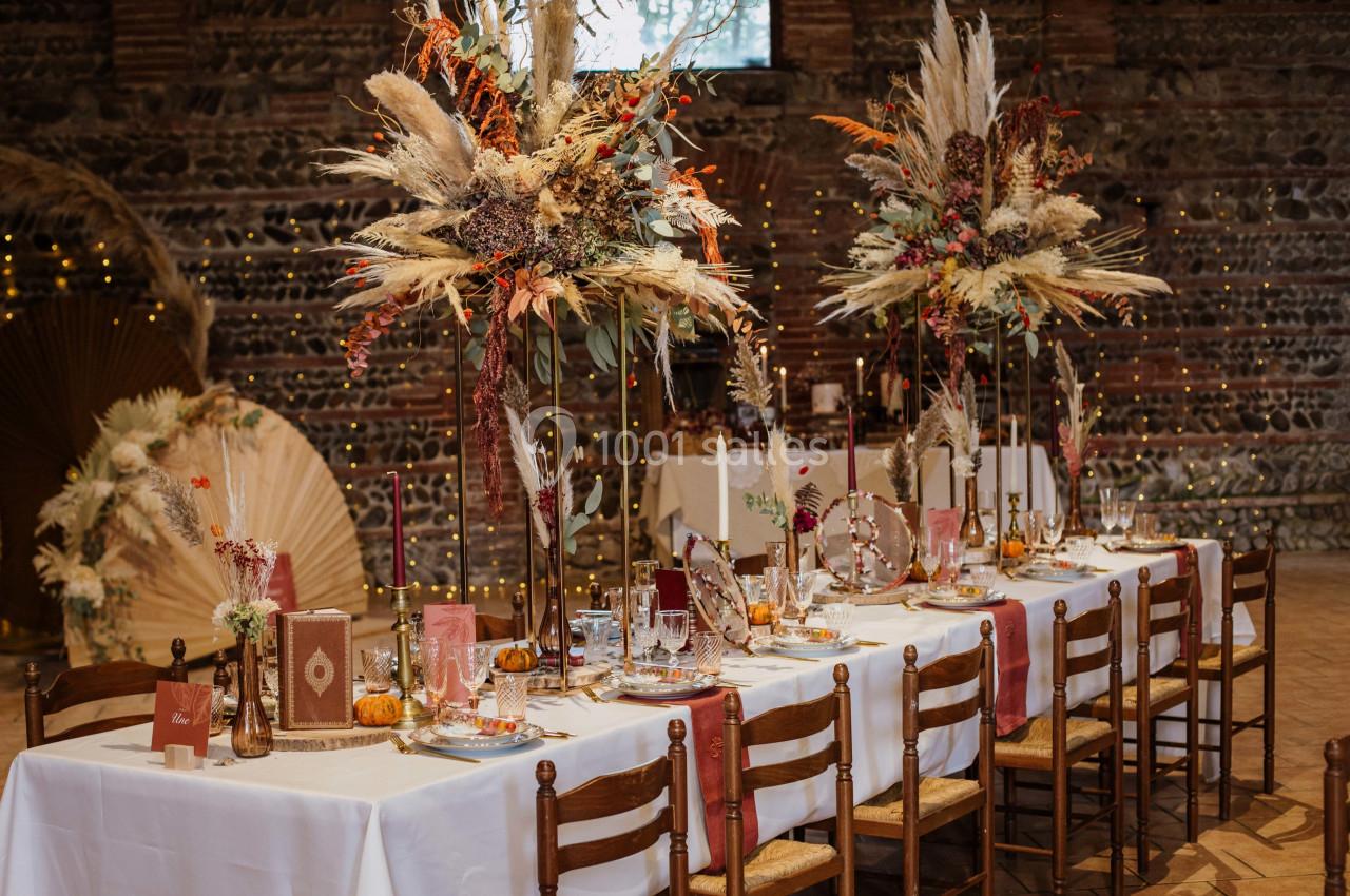 Table de réception décorée dans un style automnal avec fleurs séchées, bougies et vaisselle élégante dans une salle en…