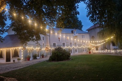 Miniature Location salle Tigeaux (Seine-et-Marne) - Le Manoir de Tigeaux #11 Des personnes souriantes posent avec des accessoires festifs et un cadre violet dans un jardin ensoleillé.