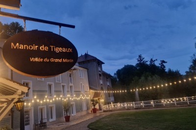Miniature Location salle Tigeaux (Seine-et-Marne) - Le Manoir de Tigeaux #8 Des personnes souriantes posent avec des accessoires festifs et un cadre violet dans un jardin ensoleillé.