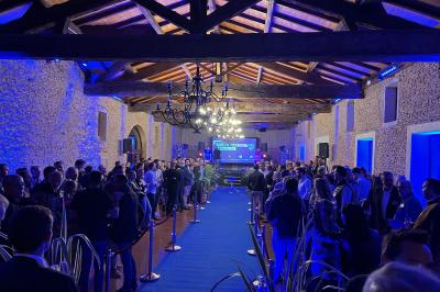 Vue intérieure d'une pièce mansardée lumineuse avec poutres apparentes, sol en bois et une grande fenêtre donnant sur des…