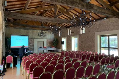 Vue intérieure d'une pièce mansardée lumineuse avec poutres apparentes, sol en bois et une grande fenêtre donnant sur des…