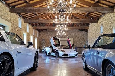 Vue intérieure d'une pièce mansardée lumineuse avec poutres apparentes, sol en bois et une grande fenêtre donnant sur des…