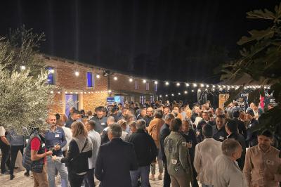 Vue intérieure d'une pièce mansardée lumineuse avec poutres apparentes, sol en bois et une grande fenêtre donnant sur des…