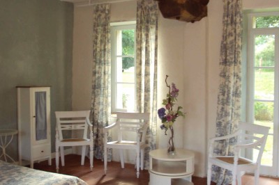 Miniature Location salle Aunou-sur-Orne (Orne) - Le Domaine de La Cour #13 Chambre mansardée avec coiffeuse blanche, chaise, commode assortie, miroir et lumière naturelle provenant d'une fenêtre.