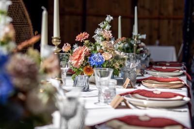 Mobilier en rotin disposé sur une pelouse, avec une table basse blanche et une décoration florale.