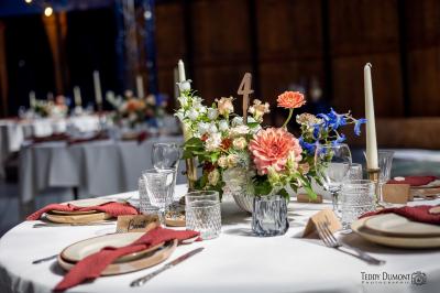Mobilier en rotin disposé sur une pelouse, avec une table basse blanche et une décoration florale.