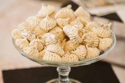Mobilier en rotin disposé sur une pelouse, avec une table basse blanche et une décoration florale.