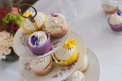 Mobilier en rotin disposé sur une pelouse, avec une table basse blanche et une décoration florale.