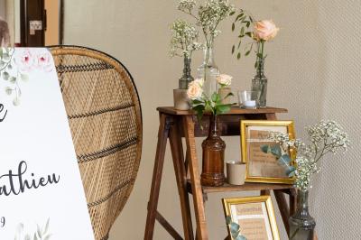 Mobilier en rotin disposé sur une pelouse, avec une table basse blanche et une décoration florale.