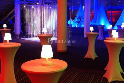 Décor hivernal avec un fauteuil rouge doré entouré de bonhommes de neige, sapins enneigés et guirlandes lumineuses.