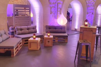 Décor hivernal avec un fauteuil rouge doré entouré de bonhommes de neige, sapins enneigés et guirlandes lumineuses.